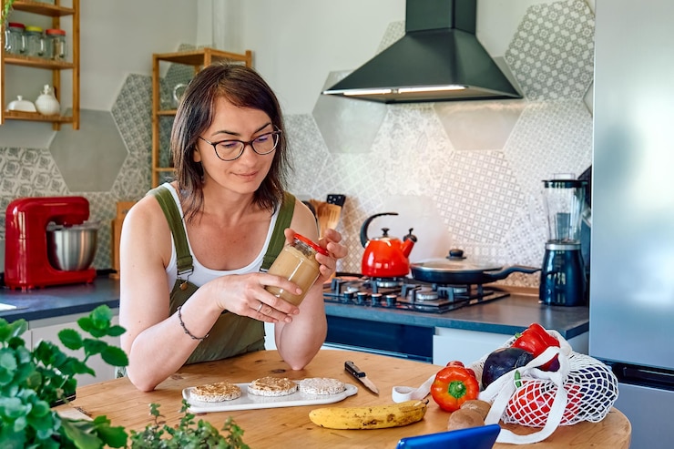 Foto mujer disfrutando de su desayuno saludable revisando su teléfono inteligente en casa