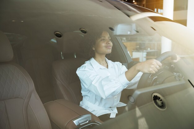 Foto mujer disfrutando de su independencia financiera mientras compra un coche