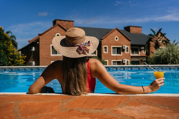 Mujer disfrutando de sus vacaciones de verano en la piscina