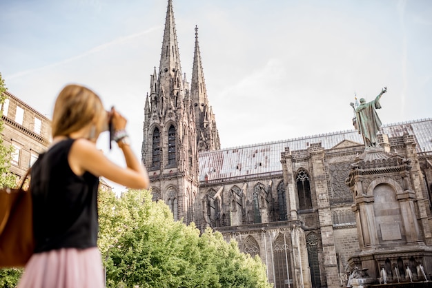 Mujer disfrutando de la vista de la mañana en la famosa catedral de la ciudad de Clermont-Ferrand en Francia. La mujer está fuera de foco