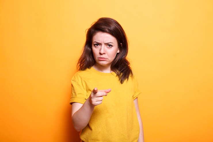 Foto una mujer disgustada señala con el dedo a la cámara.