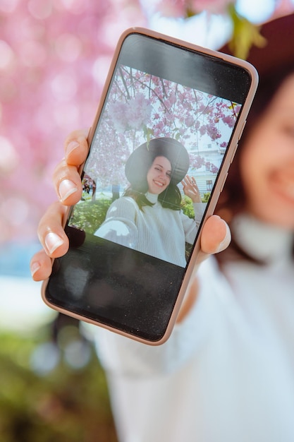 Mujer se dispara por teléfono bajo un floreciente árbol de sakura