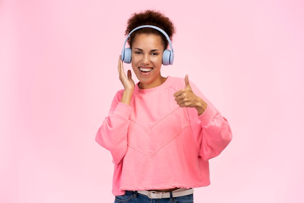 Mujer divertida feliz de pie y escuchando música con auriculares