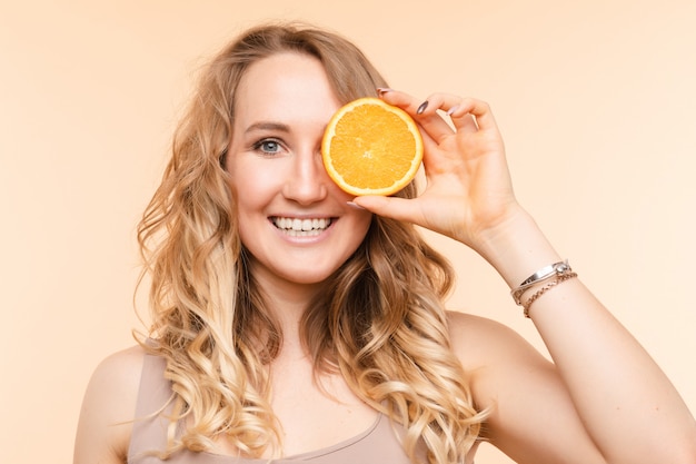 Mujer divertida de moda con peinado con naranja en ojo