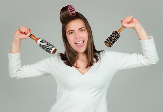 Mujer divertida peina su cabello saludable peinando cabello femenino largo y recto saludable de cerca