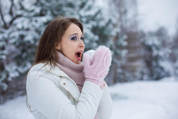 La mujer divertida prueba la nieve La mujer de mediana edad vestida con ropa de abrigo se divierte al aire libre