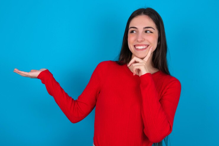Foto mujer divertida sosteniendo un producto nuevo con la palma abierta quiero comprarlo