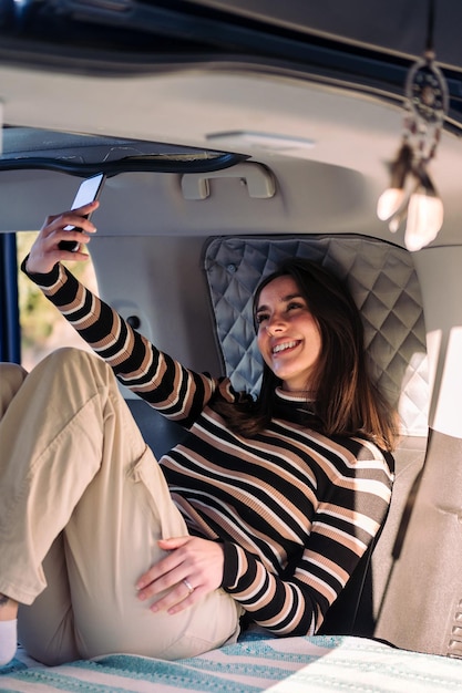 Mujer divirtiéndose en autocaravana tomando un selfie