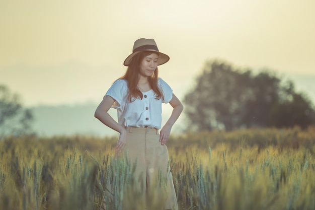 Mujer divirtiéndose en el campo de cebada en verano