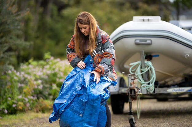 Foto mujer doblando una lona en un campamento en australia camping tant y lona mientras viaja en caravana y acampa en australia