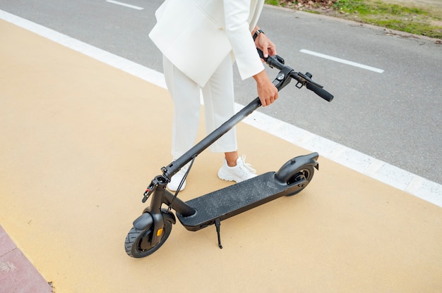 Una mujer doblando un scooter eléctrico plegable