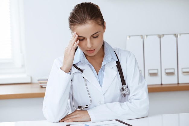 Mujer-doctor sentado y trabajando en la oficina de la clínica. Retrato de mujer médico. concepto de medicina