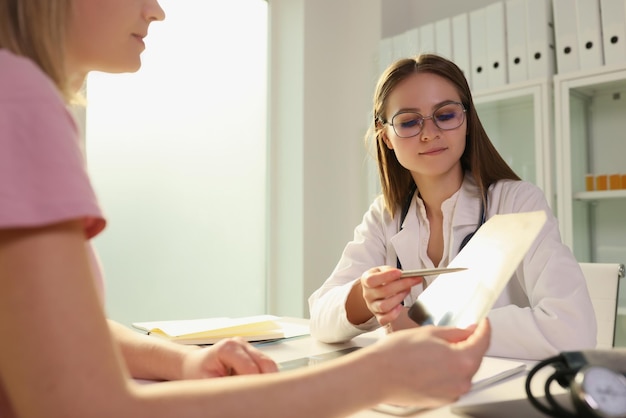 Mujer doctora que muestra rayos x al paciente en el diagnóstico clínico y tratamiento del concepto de neumonía