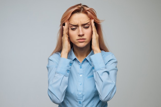 Mujer con dolor de cabeza, intenta concentrarse, masajeando las sienes, aislado. Presión