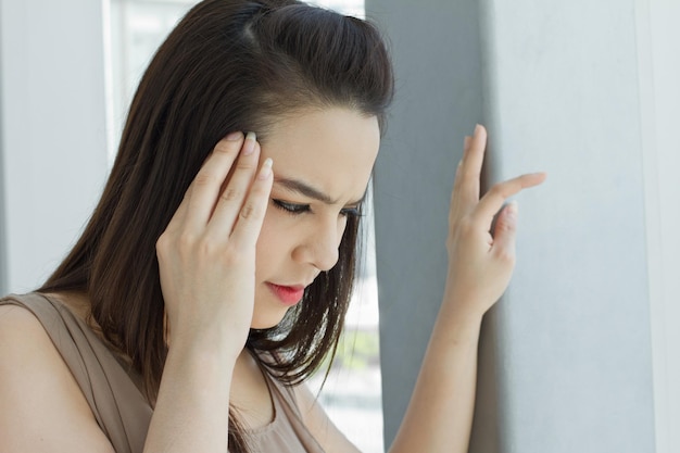 Mujer con dolor de cabeza migraña estrés insomnio resaca en vestido casual