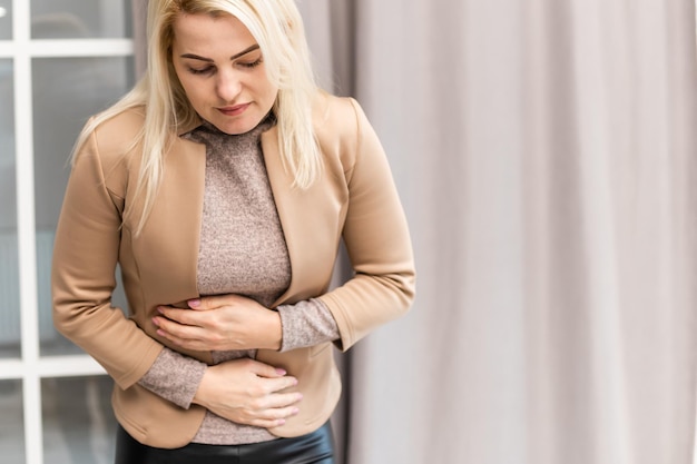 Mujer con dolor de estómago en casa.