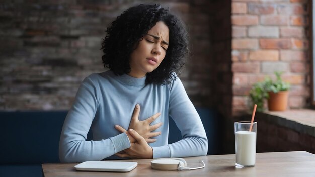 Mujer con dolor de estómago y un vaso de leche alergia a los lácteos intolerancia a la lactosa concepción