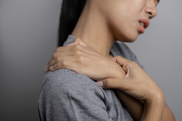 Foto mujer con dolor en el hombro.