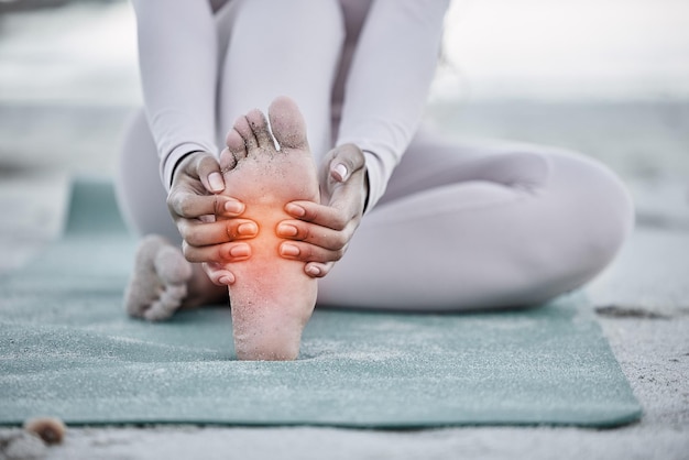 Mujer dolor de pie y lesiones en la playa después de practicar yoga estiramiento o entrenamiento para la salud y el bienestar Deportes pilates o masaje femenino pies fibromialgia o tensión muscular después de hacer ejercicio al aire libre