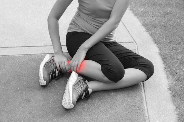 Foto mujer con dolor en la pierna en el sendero