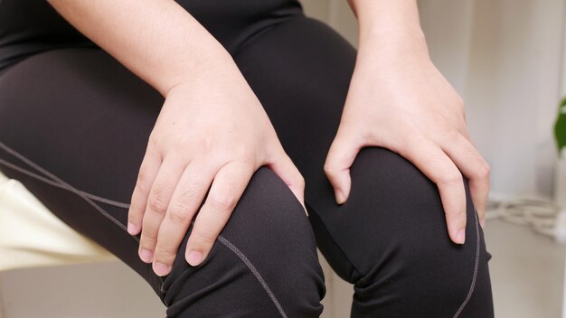 Mujer con dolor de rodilla el concepto de prevenir la fatiga de las piernas