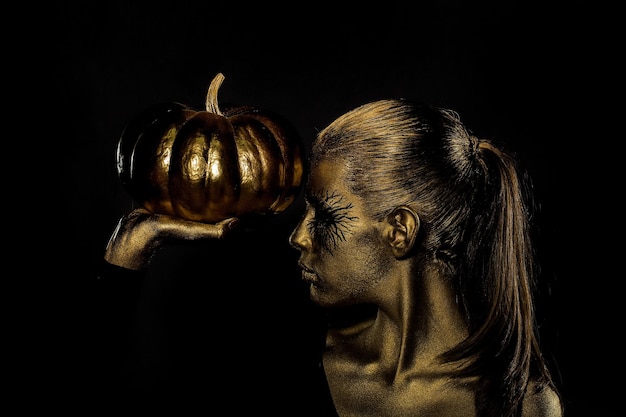 Mujer dorada con calabaza de halloween