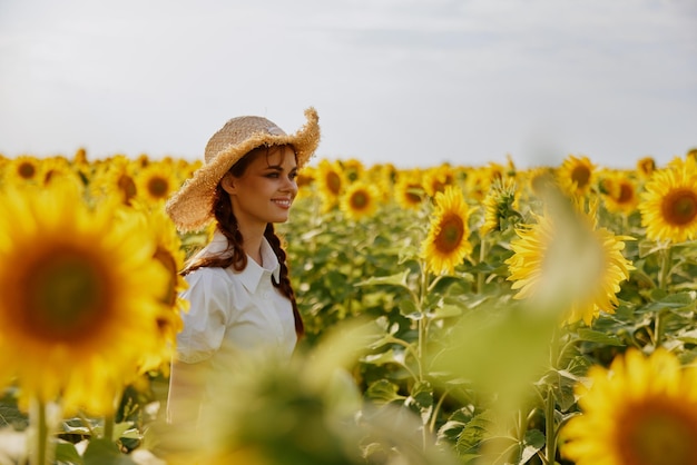 mujer con dos coletas camina a través de un campo de girasoles campo foto de alta calidad