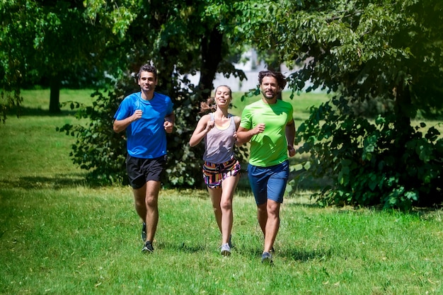 Mujer y dos jóvenes corriendo en el parque