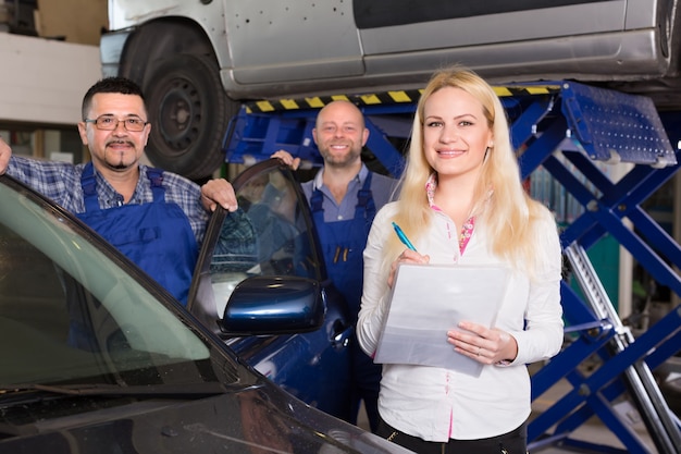 Mujer y dos mecánicos automotrices