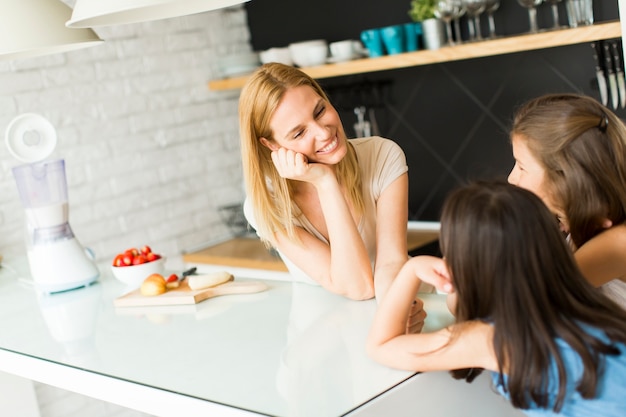 Mujer y dos niñas en la cocina