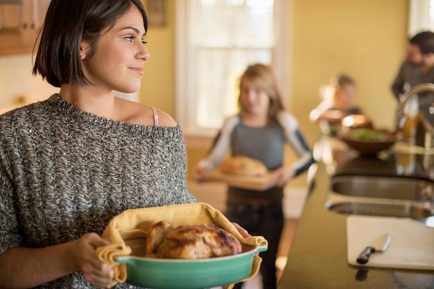 Foto una mujer y dos niñas llevando comida a una mesa.