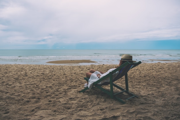 Foto una mujer se duerme y se acuesta en una silla de playa sola