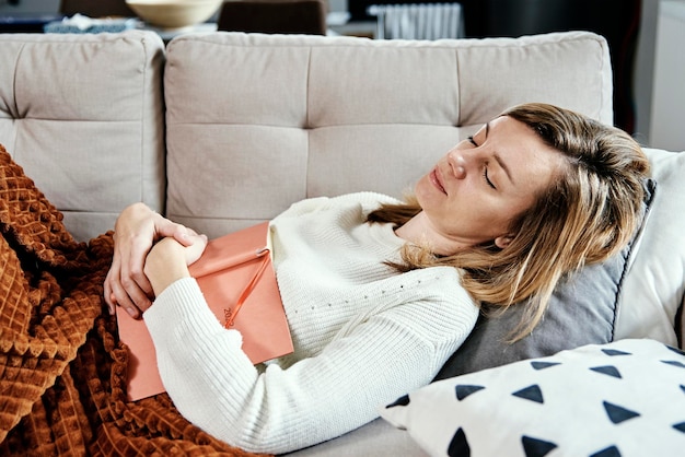 Mujer duerme en el sofá con el libro