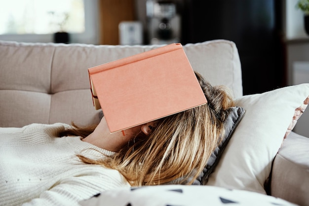 Mujer duerme en el sofá con libro
