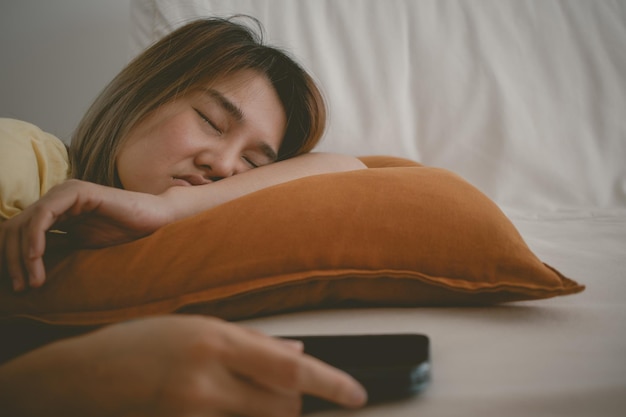 Una mujer duerme en el sofá con el teléfono móvil todavía en la mano