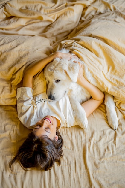 Mujer duerme con su lindo perro en la cama