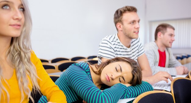 Mujer durmiendo en el aula de la universidad