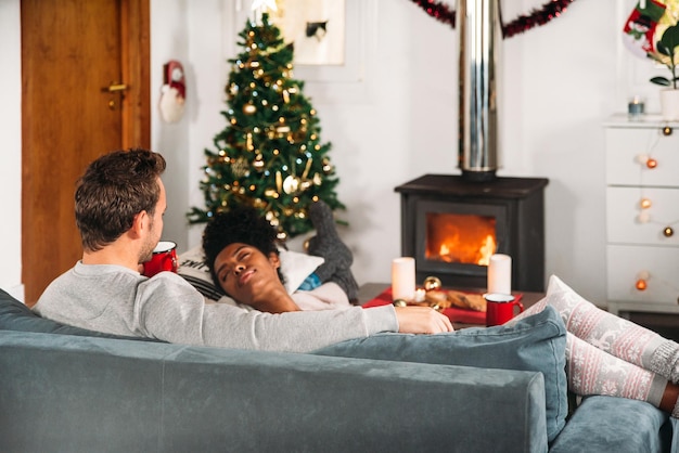 Mujer durmiendo en brazos de novio en Navidad