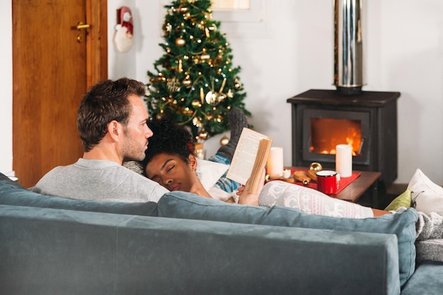 Mujer durmiendo en brazos de novio en Navidad