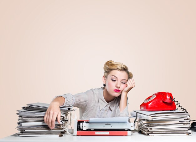 Mujer durmiendo con exceso de trabajo en el lugar de trabajo sobre fondo claro