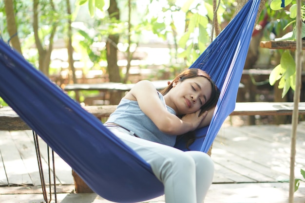 Mujer durmiendo en una hamaca en una cafetería.