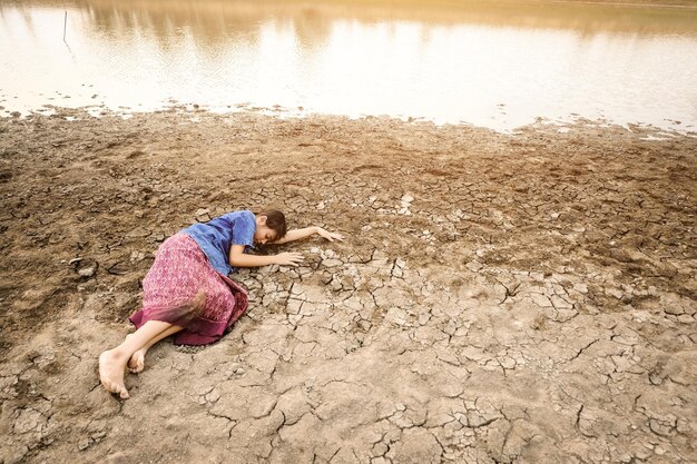 Foto mujer durmiendo en la orilla del lago