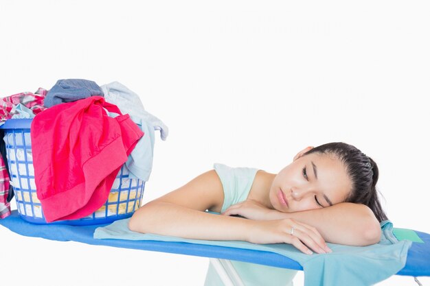 Foto mujer durmiendo en una tabla de planchar