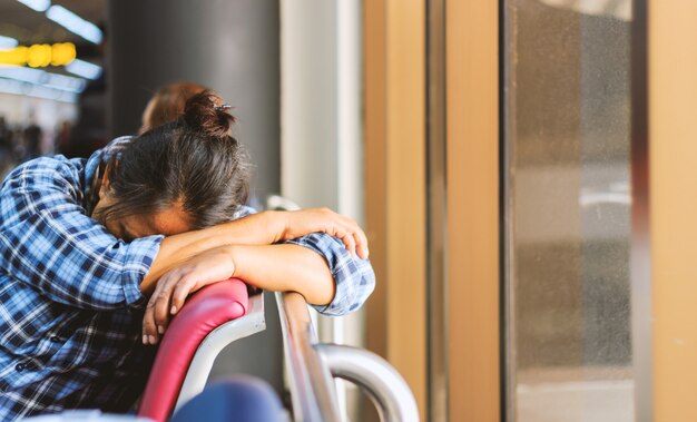 Mujer durmiendo en una terminal del aeropuerto