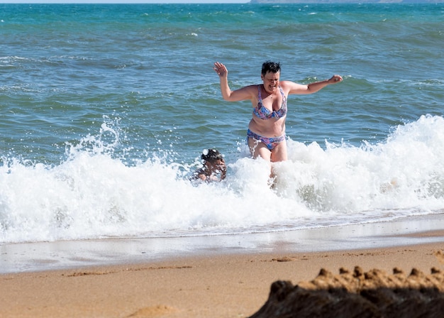 Una mujer de la edad de la espuma sale del mar