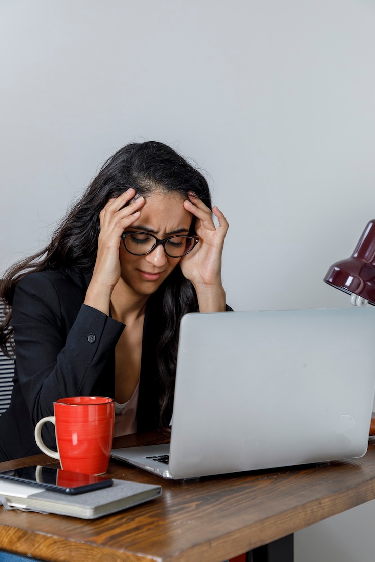 Foto mujer ejecutiva cansada por el exceso de trabalho em casa se lleva las manos a la cabeza
