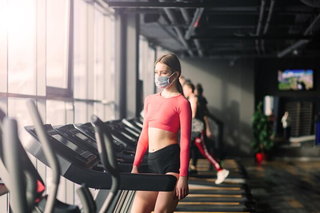 Mujer con ejercicio de mascarilla en el gimnasio durante la pandermia del virus corona.