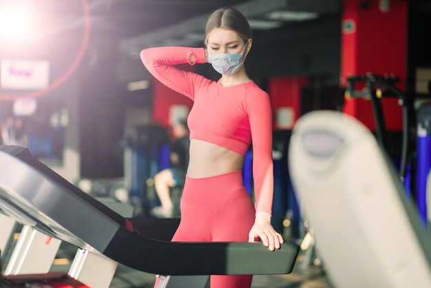 Mujer con ejercicio de mascarilla en el gimnasio durante la pandermia del virus corona.