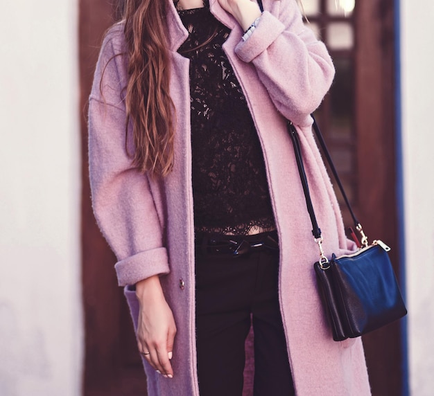 Mujer elegante con abrigo caminando por la ciudad