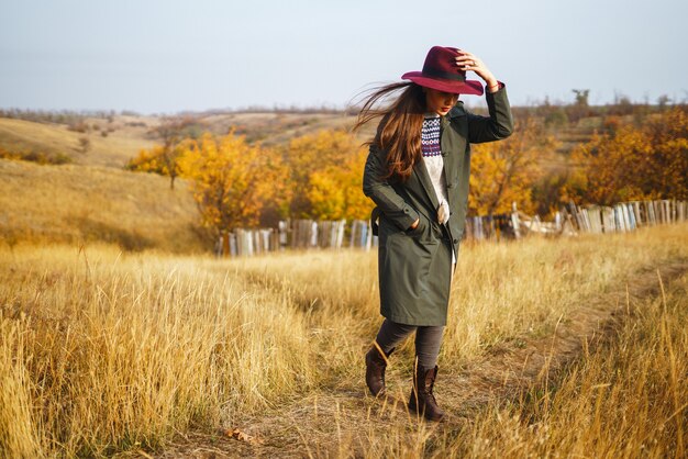 Mujer elegante con un abrigo en el parque de otoño